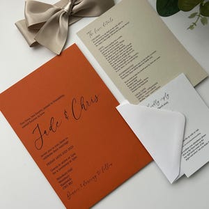 Pode incluir: Um convite de casamento com fundo laranja e texto preto. O convite diz: "Duas vidas, dois cora&ccedil;&otilde;es, unidos pela amizade, unidos para sempre pelo amor. Jade & Chris. Convidamos voc&ecirc; a se juntar a eles para celebrar seu casamento. Sexta-feira, 18 de julho de 2025. Os convidados devem chegar &agrave;s 13h para uma cerim&ocirc;nia &agrave;s 14h. Wrenbury Hall, Wrenbury, Nantwich, CWS BEJ. Jantar e dan&ccedil;a a seguir."