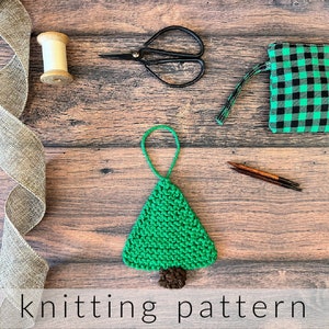 以下が含まれることがあります： 緑のクリスマスツリーのオーナメントの編み物パターン。オーナメントは、幹に茶色の糸、木に緑色の糸を使って作られています。パターンには、木と幹を編むための指示が含まれています。