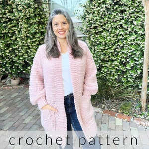 May include: A pink crochet cardigan with pockets and long sleeves. The cardigan is open in the front and has a relaxed fit.  crochet pattern