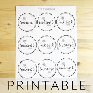 Puede incluir: Hoja imprimible con nueve círculos, cada uno con la palabra "bookmark" en una fuente estilizada. La hoja está diseñada para imprimir 2 1/4 pulgadas de diámetro, o 60 mm.
