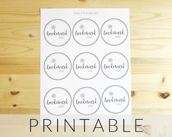 Puede incluir: Hoja imprimible con nueve círculos, cada uno con la palabra "bookmark" en una fuente estilizada. La hoja está diseñada para imprimir 2 1/4 pulgadas de diámetro, o 60 mm.
