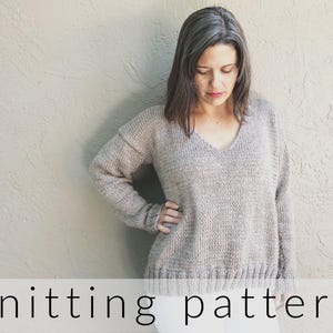May include: A long-sleeved, V-neck knitted sweater in a heathered beige color with a ribbed hem and cuffs. The text "knitting pattern" is printed in black at the bottom, and "ChristaCoDesign.com" is printed vertically on the right side.
