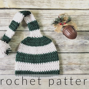 May include: Green and white striped crochet elf hat with a white pom pom. The hat is on a wooden background with the text "crochet pattern" below it.