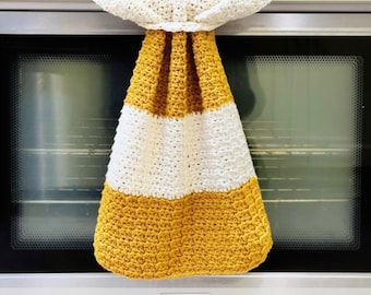 May include: A crocheted kitchen towel with a white and yellow striped design. The towel is hanging on an oven door handle. The towel has a loop at the top for hanging.