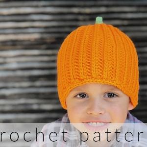 May include: A child wearing an orange crocheted pumpkin hat. The hat has a green stem on top. The child is smiling and looking at the camera. crochet pattern