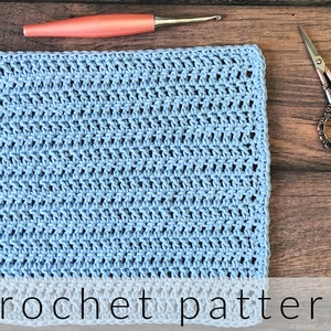 May include: A light blue crochet square with a crochet hook and scissors on a wooden surface. The text "crochet pattern" is at the bottom of the image.