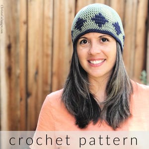 May include: A crochet hat pattern featuring a green and blue color scheme with a flower design. The hat is worn by a person with long brown hair. The image includes the text "crochet pattern".
