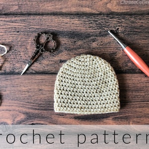 May include: A beige crochet hat with a crochet hook and yarn on a wooden background. The text "crochet pattern" is at the bottom of the image.