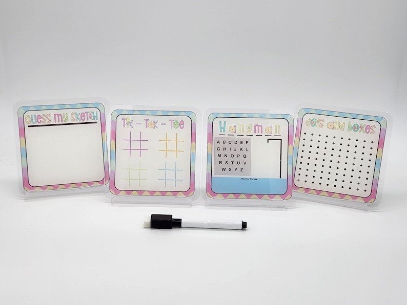 May include: Four white dry-erase boards with colorful borders and different games: Guess My Sketch, Tic-Tac-Toe, Hangman, and Dots and Boxes. A white dry-erase marker is included.