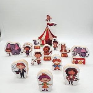 Op de afbeelding: Een set houten speelgoedfiguren die een circus thema voorstellen. De set bevat een clown, een leeuw, een olifant, een goochelaar en andere personages. De figuren zijn geschilderd in felle kleuren en hebben een fantasierijk ontwerp.