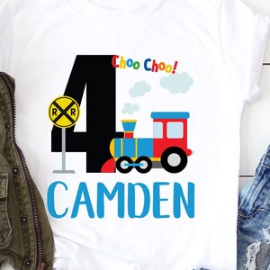 May include: A white t-shirt with a black number four, a red, blue, and yellow train, and the text "Choo Choo!" and "CAMDEN".
