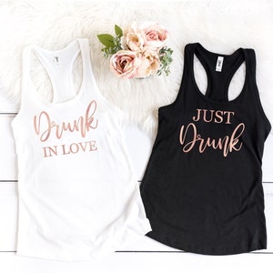 May include: Two tank tops with rose gold lettering. One white tank top says "Drunk in Love" and one black tank top says "Just Drunk".