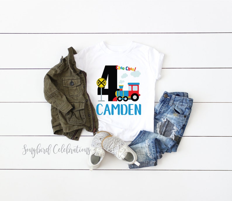 May include: White t-shirt with a black number 4, a colorful train, and the text "Choo Choo!" and "CAMDEN".