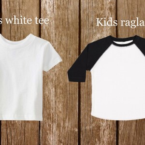 May include: Two blank white t-shirts, one with short sleeves and the other with long sleeves and black raglan sleeves. The text "Kids white tee" is above the short-sleeved shirt and "Kids raglan" is above the long-sleeved shirt.