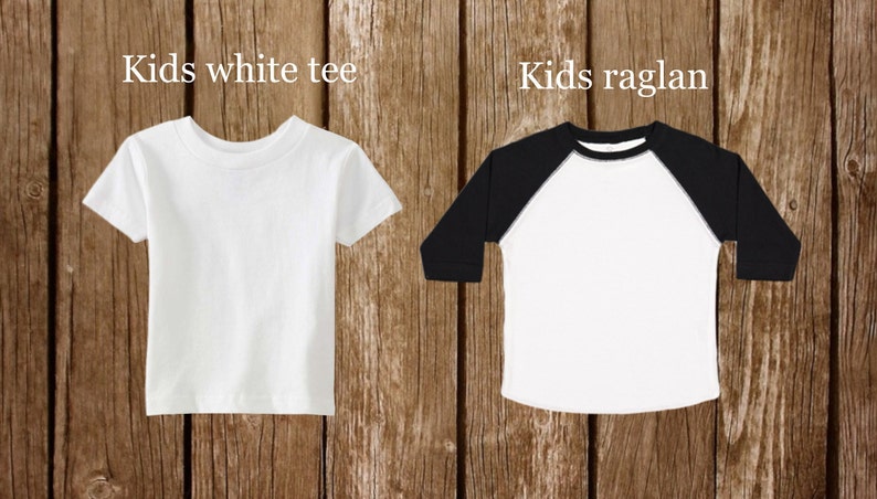 May include: Two blank white t-shirts, one with short sleeves and the other with long sleeves and black raglan sleeves. The text "Kids white tee" is above the short-sleeved shirt and "Kids raglan" is above the long-sleeved shirt.
