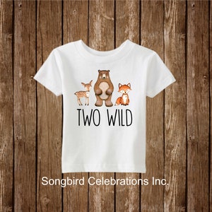 May include: White t-shirt with a brown bear, a deer, and a fox printed on it. The text "TWO WILD" is printed below the animals.