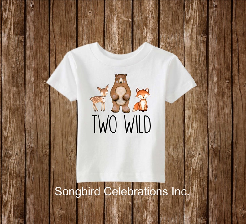 May include: White t-shirt with a brown bear, a deer, and a fox printed on it. The text "TWO WILD" is printed below the animals.