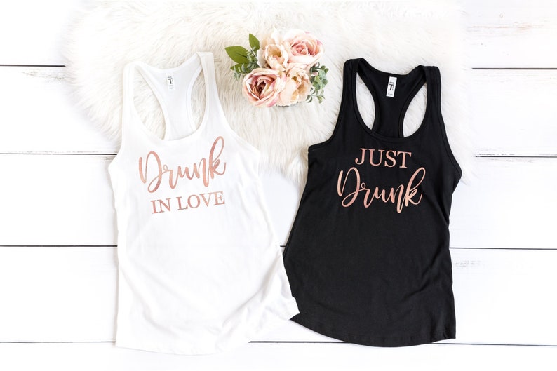 May include: Two white tank tops with rose gold lettering. One tank top says "Drunk in Love" and the other says "Just Drunk".