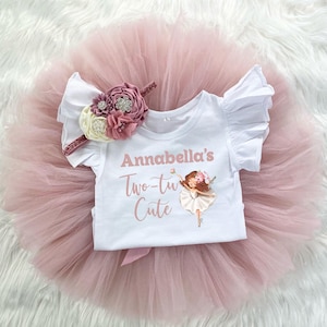 May include: A white tutu with a pink tulle skirt and a white shirt with a pink flower headband. The shirt has the text "Annabella's Two-tu Cute" and a ballerina illustration.