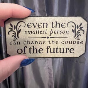 Puede incluir: Un letrero beige con texto negro y adornos decorativos dice "incluso la persona más pequeña puede cambiar el curso del futuro."