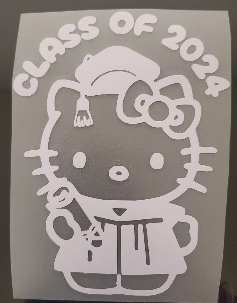May include: White vinyl sticker of Hello Kitty dressed in a graduation cap and gown, holding a diploma. The text "Class of 2024" surrounds the character.