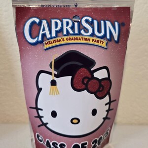 May include: A pink Capri Sun juice pouch with a Hello Kitty design. Hello Kitty is wearing a graduation cap and a red bow. The text "Melissa's Graduation Party" and "Class of 2015" are printed on the pouch.