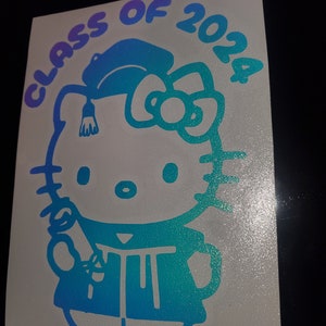 May include: A blue and purple gradient vinyl sticker featuring Hello Kitty dressed in a graduation cap and gown, holding a diploma. The sticker says "Class of 2024" around the top.