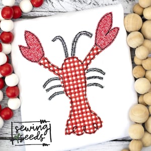 May include: Red and white gingham lobster applique with black stitching. The lobster has two large claws and a smaller tail. The applique is on a white background.
