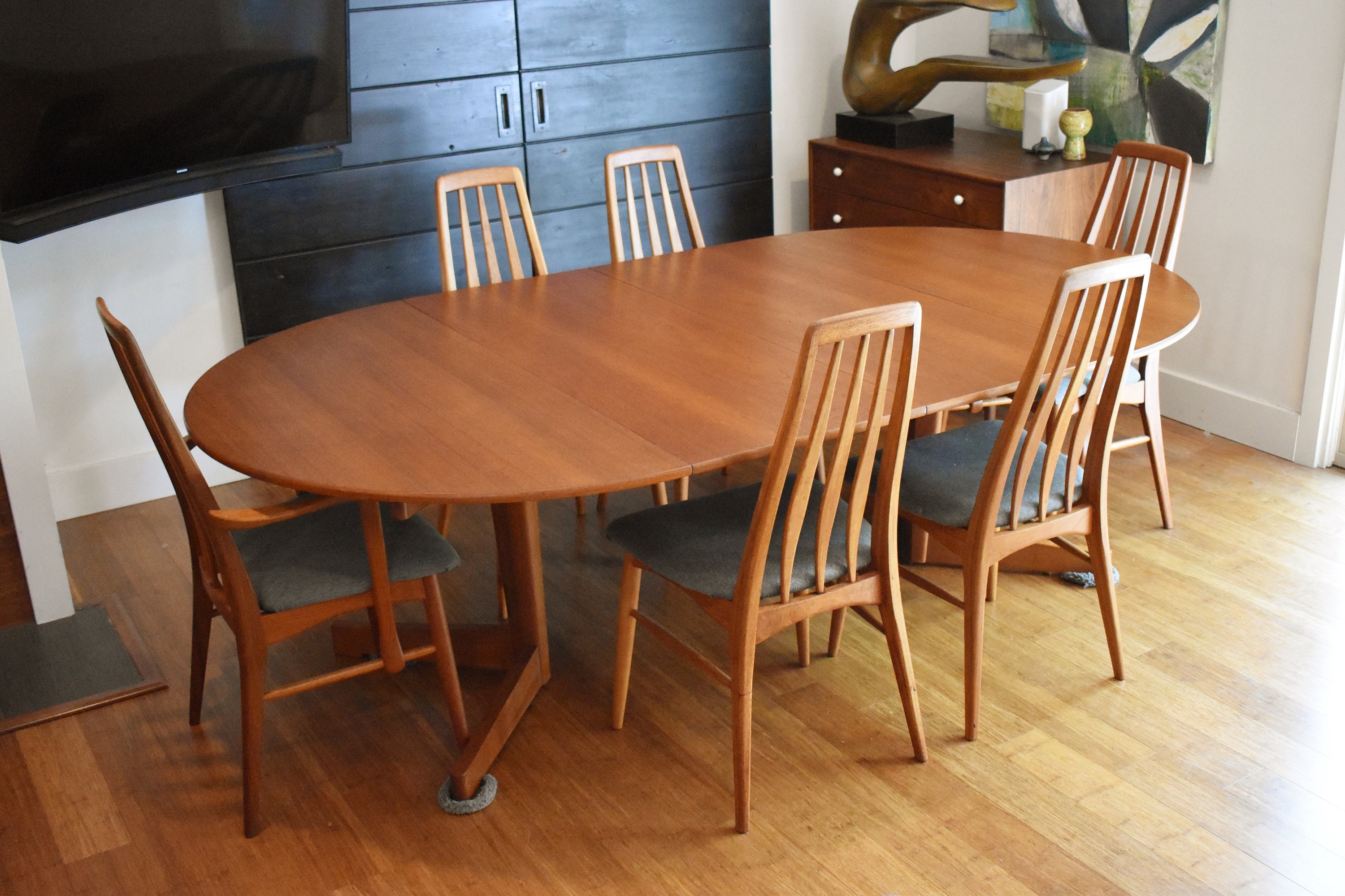 Restored Danish teak round to oval expandable dining table by Arne
