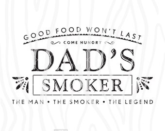 May include: Black and white sign with the text "Good food won't last, come hungry, Dad's Smoker, The man, the smoker, the legend". The sign has a woodgrain background and a small heart with the text "Woodworks" in the bottom right corner.