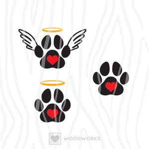May include: Two black paw prints with a red heart in the center. One paw print has a gold halo and angel wings. The other paw print has a gold halo. The text "WOODWORKS" is at the bottom of the image.