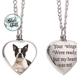Op de afbeelding: Zilveren hartvormige crematieketting met een foto van een Boston Terrier aan de ene kant en de inscriptie "Je vleugels waren klaar, maar mijn hart was het niet" aan de andere kant.