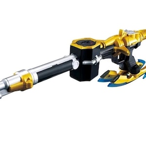 Peut inclure: Une arme jouet dorée, noire et argentée au design futuriste. Le jouet a un long canon, une poignée et une gâchette. La base a des accents bleus. Le jouet est probablement un accessoire de costume ou de jeu.