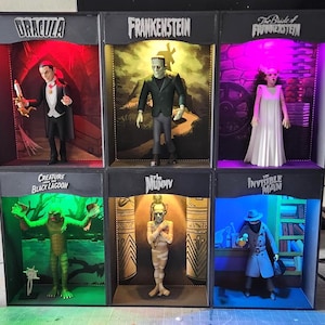 May include: Six miniature horror movie character figures displayed in individual illuminated boxes. Characters include Dracula, Frankenstein, The Bride of Frankenstein, Creature from the Black Lagoon, The Mummy, and The Invisible Man.