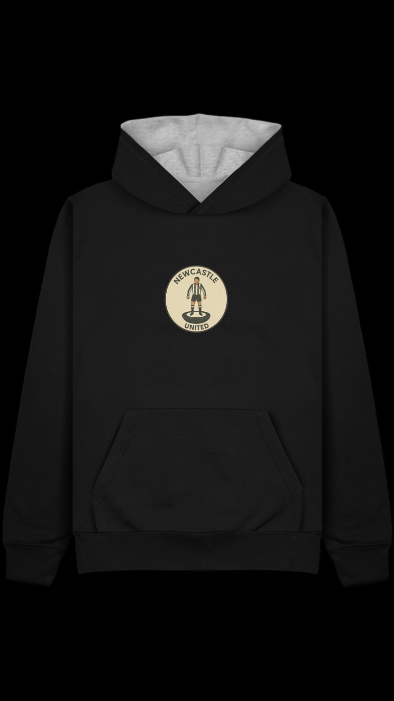 Peut inclure: Sweat &agrave; capuche noir avec une capuche doubl&eacute;e grise et une poche kangourou. L'avant pr&eacute;sente un &eacute;cusson circulaire avec le texte "Newcastle United" et un joueur de football stylis&eacute;.