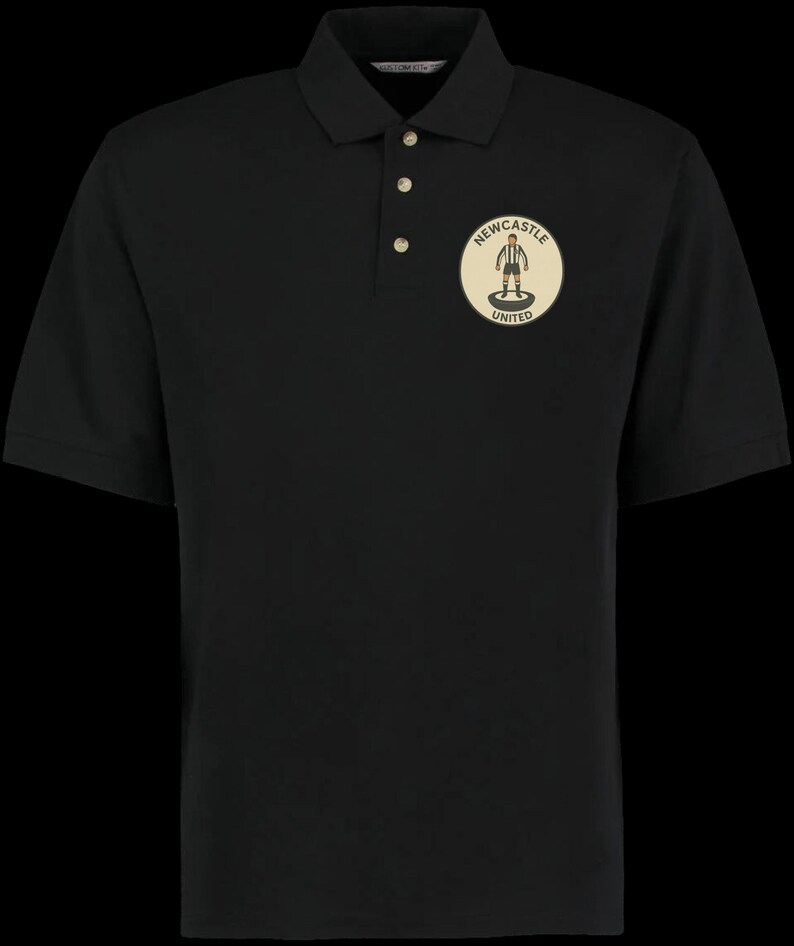 Peut inclure: Polo noir &agrave; manches courtes avec une patte de boutonnage &agrave; trois boutons. Il pr&eacute;sente un &eacute;cusson circulaire sur la poitrine avec le texte "Newcastle United" et une figurine de joueur de football.
