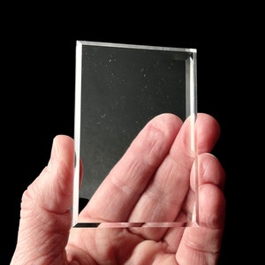 Könnte beinhalten: Eine transparente Glasvitrine mit abgeschrägter Kante.