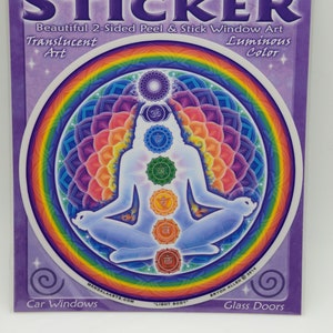 Puede incluir: Una pegatina redonda y colorida para ventanas con un diseño de mandala con una persona sentada en una postura meditativa. La pegatina es translúcida y brilla en la oscuridad. La pegatina está etiquetada como "Window Sticker" y "Light Body".