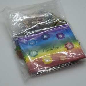 May include: A plastic bag containing a set of seven chakra cards. The cards are rainbow colored and feature symbols and the word "Chakras".