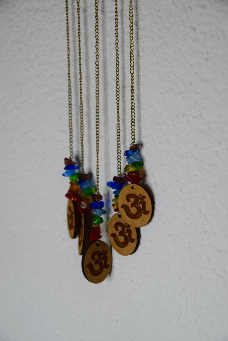 May include: Five gold chains with colorful glass beads and wooden pendants with the Om symbol.