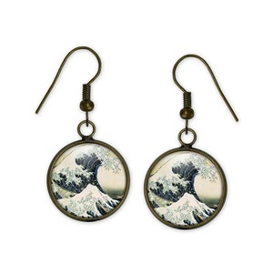 May include: A pair of bronze-colored earrings with a round, glass pendant featuring a reproduction of the famous Japanese woodblock print "The Great Wave off Kanagawa" by Katsushika Hokusai.