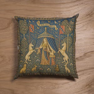 May include: A square throw pillow featuring a reproduction of The Lady and the Unicorn tapestry. The design displays a central figure standing under a blue tent with the text A MON SEVL DESIR, flanked by two unicorns, a lion, a rabbit, and a dog.