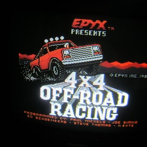 Puede incluir: Pantalla de videojuego retro con un camión 4x4 rojo. El título del juego "4x4 Off-Road Racing" aparece en texto blanco. El logotipo de Epyx y los créditos de programación también son visibles sobre fondo negro, evocando una estética de juego clásica.