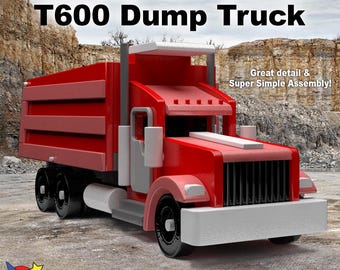 May include: A red Kenworth T600 dump truck toy model made of wood. The truck has a white cab and a gray bed. The truck is on a gray surface. The text "Famous Kenworth T600 Dump Truck" is at the top of the image. The text "Great detail & Super Simple Assembly!" is on the right side of the image. The text "Wood Toy Plans & Patterns" is at the bottom of the image.