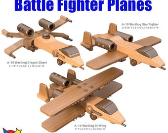 May include: Three wooden toy airplane models of the A-10 Warthog, a military aircraft. The models are painted in a natural wood color and have detailed features. The models are labeled with their names and dimensions: A-10 Warthog Star Fighter, A-10 Warthog Dragon Slayer, and A-10 Warthog Bi-Wing. The text "Wood Toy Patterns" is at the bottom of the image.