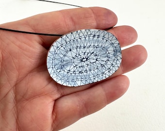 Oval Copper and Enamel Blue and White Pendant with Hand Drawn Pattern.