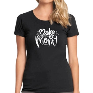K&ouml;nnte beinhalten: Schwarzes T-Shirt mit wei&szlig;em Text, der in einer stilisierten Schrift "Mach dich selbst zur Priorit&auml;t" lautet.