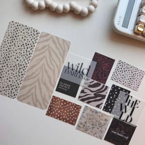 May include: A collection of rectangular stickers featuring various animal print patterns including leopard, cheetah, and zebra designs. Some stickers display the text "wild darling", "be afraid and do it anyway", "THE WILD", and "Do it for your future self".
