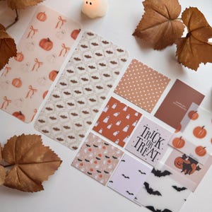 May include: A collection of rectangular and square cards featuring Halloween-themed patterns including orange pumpkins, white ghosts, black bats, and polka dots. One card displays the black text Trick or Treat, while another features a black cat.