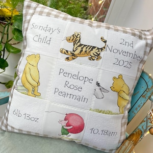 Può includere: Un cuscino per bambini personalizzato con un design patchwork. Il cuscino presenta immagini ricamate dei personaggi di Winnie the Pooh, il nome "Penelope Rose Pearmain", data di nascita, ora e peso. Il cuscino ha un bordo a quadretti.